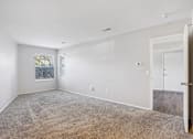 Thumbnail 21 of 57 - A spacious room with a carpeted floor and a door on the right side  at Millennium at Creve Coeur, Missouri