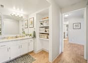 Thumbnail 21 of 62 - A bathroom with white cabinets and a marble countertop.