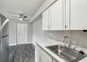 Thumbnail 20 of 45 - A kitchen with a stainless steel refrigerator, sink, and ceiling fan at Spyglass Creek, Denver, 80224