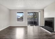 Thumbnail 13 of 44 - A room with a fireplace and sliding glass doors. at Windmill Apartments, Colorado Springs