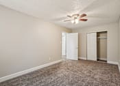 Thumbnail 14 of 56 - A room with a ceiling fan and carpeted floor.at Aspen Townhomes, Colorado Springs, CO