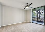 Thumbnail 12 of 55 - A room with a ceiling fan and sliding glass doors. at Lakeside Glen Apartments, Florida