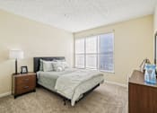 Thumbnail 8 of 32 - A bedroom with a bed, nightstand, and window. at Cedar Springs Apartments, Raleigh, NC, 27609