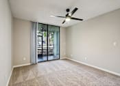 Thumbnail 13 of 55 - A room with a ceiling fan and sliding glass doors leading to a patio. at Lakeside Glen Apartments, Melbourne, Florida