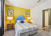 Thumbnail 17 of 36 - Bedroom with blue upholstered headboard and yellow wall at The Arbor Walk Apartments, Tampa, 33617
