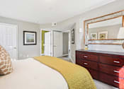 Thumbnail 11 of 41 - A bedroom with a bed, dresser, and mirror.