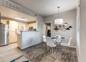 Thumbnail 6 of 105 - A modern kitchen with a dining table set for four at Sweetwater At Metro North Apartments, Arizona 85029