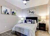 Thumbnail 10 of 105 - A bedroom with a bed, nightstand, and two wall art pieces at Sweetwater At Metro North Apartments, Phoenix, AZ 85029