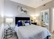 Thumbnail 12 of 105 - A bedroom with a bed, nightstand, and a painting on the wall at Sweetwater At Metro North Apartments, Arizona