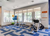 Thumbnail 80 of 105 - A gym with a blue and white checkered floor and exercise equipment at Sweetwater At Metro North Apartments, Arizona 85029