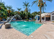 Thumbnail 86 of 105 - A pool with a waterfall and palm trees in the background at Sweetwater At Metro North Apartments, Arizona 85029