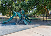 Thumbnail 98 of 105 - A playground with a green slide and a climbing structure at Sweetwater At Metro North Apartments, Phoenix, AZ 85029