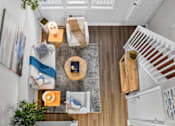 Thumbnail 9 of 64 - A living room with a couch, a coffee table, and a staircase.at Lofts of Wilmington, Wilmington, NC, 28405
