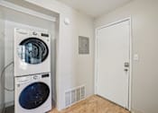 Thumbnail 39 of 62 - A white door is in a room with a washer and dryer.