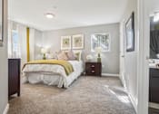 Thumbnail 13 of 41 - A bedroom with a bed, nightstand, and two lamps.