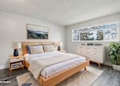 Thumbnail 18 of 45 - A bedroom with a large bed, a nightstand with a lamp, and a painting on the wall. at Spyglass Creek, Denver, 80224