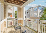 Thumbnail 11 of 32 - A balcony with a table and chairs overlooks a residential area. at Cedar Springs Apartments, Raleigh, 27609