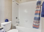 Thumbnail 20 of 51 - a bathroom with a toilet and a tub and a shower curtain at The Glen at Highpoint, Dallas, 75243