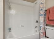 Thumbnail 14 of 51 - a bathroom with a tub and a toilet and a shower curtain at The Glen at Highpoint, Dallas, 75243
