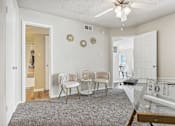 Thumbnail 11 of 51 - a living room with a glass table and chairs and a ceiling fan at The Glen at Highpoint, Dallas, 75243