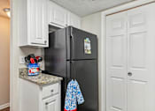 Thumbnail 9 of 51 - a kitchen with a black refrigerator and white cabinets at The Glen at Highpoint, Dallas, 75243