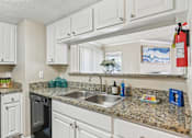 Thumbnail 7 of 51 - a kitchen with white cabinets and granite counter tops and a sink at The Glen at Highpoint, Dallas, 75243