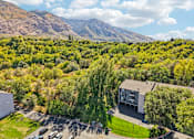 Thumbnail 55 of 62 - A building is surrounded by a green landscape and a mountain in the background at Cliffs at Canyon Ridge, Ogden, UT, 84401