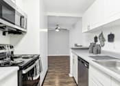 Thumbnail 43 of 57 - A modern kitchen with white cabinets and a black stove top.
