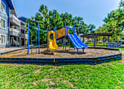 Thumbnail 37 of 44 - A playground with a blue slide and yellow slide. at Windmill Apartments, Colorado Springs, CO, 80916