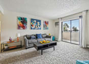 Thumbnail 1 of 45 - A living room with a grey couch, a coffee table, and two paintings on the wall at Spyglass Creek, Denver, 80224