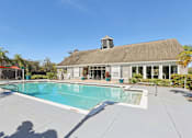 Thumbnail 24 of 36 - Community pool with clubhouse and surrounding deck at The Arbor Walk Apartments, Tampa, 33617