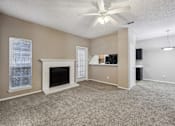 Thumbnail 14 of 27 - A living room with a fireplace and a ceiling fan.