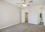 Thumbnail 29 of 51 - a bedroom with a ceiling fan and a door to a bathroom at The Glen at Highpoint, Dallas, 75243