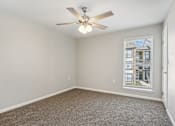 Thumbnail 27 of 51 - an empty living room with a ceiling fan and a window at The Glen at Highpoint, Dallas, 75243
