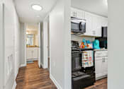 Thumbnail 26 of 51 - a renovated kitchen with white cabinets and a black stove and microwave at The Glen at Highpoint, Dallas, 75243