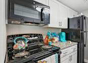 Thumbnail 31 of 51 - a kitchen with a stove and microwave and a refrigerator at The Glen at Highpoint, Dallas, 75243