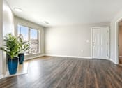 Thumbnail 22 of 51 - an empty living room with a white door and a potted plant at The Glen at Highpoint, Dallas, 75243