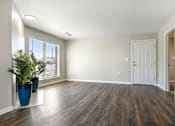 Thumbnail 33 of 51 - an empty living room with a potted plant and a white door at The Glen at Highpoint, Dallas, 75243