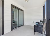 Thumbnail 28 of 51 - a covered patio with two chairs and a sliding glass door at The Glen at Highpoint, Dallas, 75243