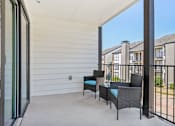 Thumbnail 32 of 51 - a patio with chairs and a table and a sliding glass door at The Glen at Highpoint, Dallas, 75243