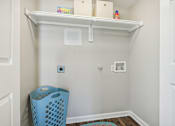 Thumbnail 39 of 51 - a small laundry room with a blue laundry basket and a shelf at The Glen at Highpoint, Dallas, 75243