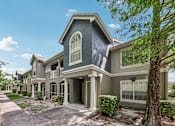 Thumbnail 21 of 31 - A house with a grey front and a tree in front at The Parkway at Hunters Creek, Orlando, 32837