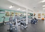 Thumbnail 25 of 32 - A gym with a variety of exercise equipment including treadmills, stationary bikes, and weight machines. at Cedar Springs Apartments, Raleigh, NC, 27609