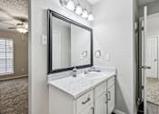 Thumbnail 22 of 27 - A bathroom with a sink, mirror, and a ceiling fan.