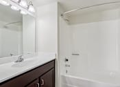 Thumbnail 34 of 47 - A white bathroom with a sink, mirror, and bathtub at Del Coronado Apartment, Mesa, AZ, 85202