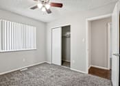 Thumbnail 17 of 56 - A room with a ceiling fan and a window with blinds.at Aspen Townhomes, Colorado Springs, 80909