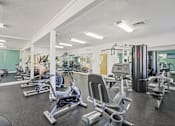 Thumbnail 28 of 32 - A gym with a row of exercise bikes. at Cedar Springs Apartments, Raleigh, North Carolina