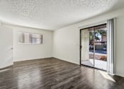 Thumbnail 29 of 47 - A room with wooden floors and a sliding glass door at Del Coronado Apartment , Mesa, AZ