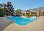 Thumbnail 30 of 32 - A swimming pool with a diving board and lounge chairs. at Cedar Springs Apartments, Raleigh, North Carolina
