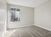 Thumbnail 22 of 44 - A room with a carpeted floor and a window. at Windmill Apartments, Colorado Springs, Colorado